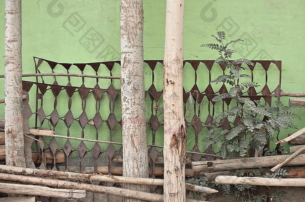靠在绿色墙上的生锈的旧金属床底座。和田-新疆-中国-0185