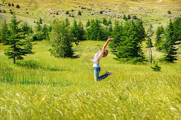 快乐快乐的女人享受<strong>自由</strong>，跳跃在鲜绿色的山谷，活跃的夏季<strong>旅<strong>游</strong>