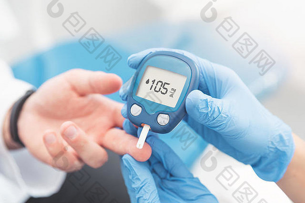 医生用血糖仪检查血糖水平。糖尿病的治疗理念。