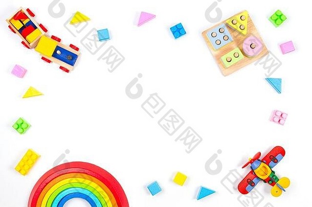 婴儿玩具背景。木制教育几何积木玩具，木制火车，彩虹，飞机和白色背景上的彩色积木