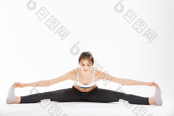 年轻的女人锻炼瑜伽支持头手倒立