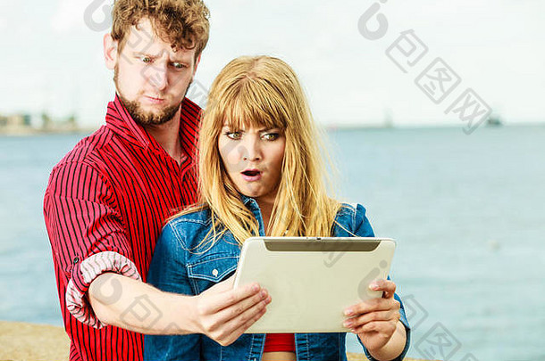 <strong>科技节</strong>日与快乐理念。年轻夫妇在海边户外用平板电脑自拍