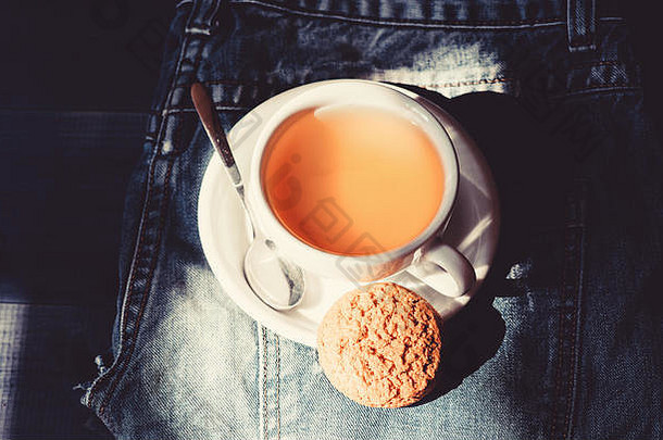 快餐概念。放松甘菊茶。一杯热茶和燕麦饼干。杯子里装满了茶。草本植物的绿色或黑色全叶。工艺茶冲泡陶瓷杯。灵感和平静的心情。