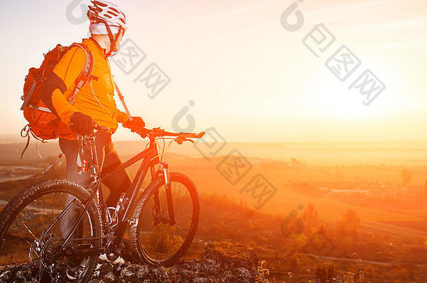 日落时，骑自行车的人和山地车站在小路上的低角度视图
