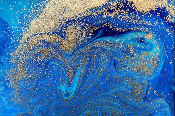 大理石蓝色抽象背景和金色亮片。液体大理石墨水图案。