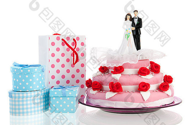 粉红色婚礼蛋糕上的情侣，白色背景上的礼物相互隔离