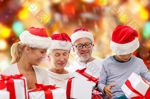 戴着圣诞老人助手帽子和礼品盒的幸福家庭
