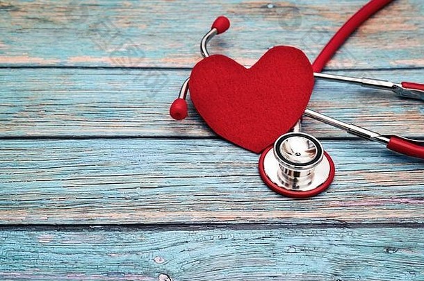 <strong>世界卫生日</strong>，医疗保健和医疗概念，蓝色木质背景上的红色听诊器和红色心脏