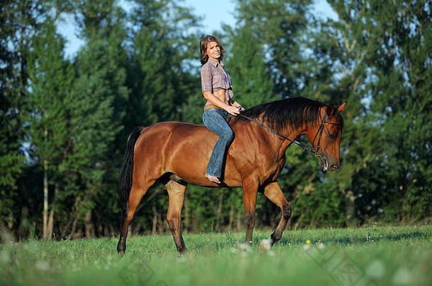 日落时分，美丽的牛仔女郎光着背在林间空地上骑马