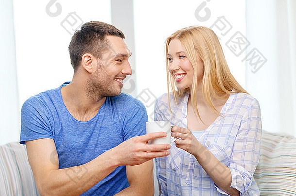 微笑的男人给妻子一杯茶或咖啡