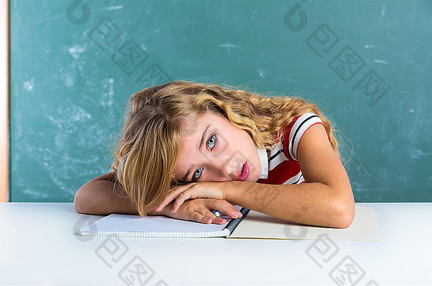 无聊悲伤的表情学生女学生在学校的课桌上绿色黑板