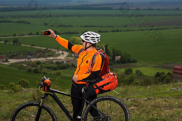 骑自行车的人用智能手机拍照。
