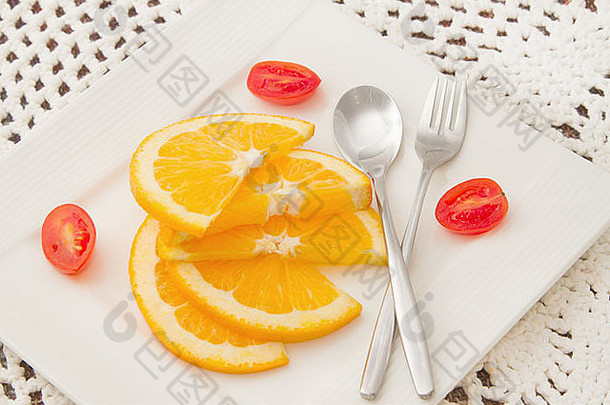 切片橙子白色板红色的番茄