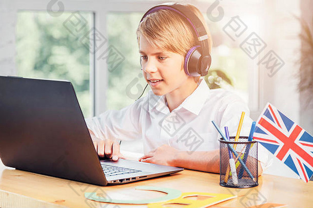 一个年轻的小学生用笔记本电脑写在线英语