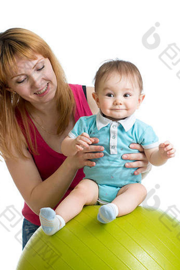 妈妈带着快乐的宝宝做体操球练习。关心儿童健康的理念。