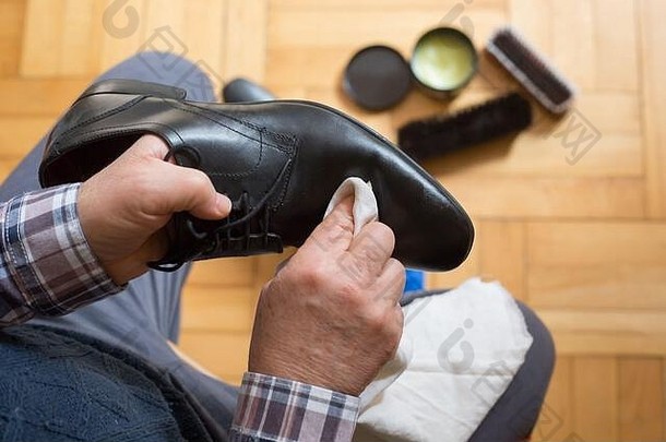 男子用抹布和鞋蜡擦鞋，以改善鞋子状况，擦鞋