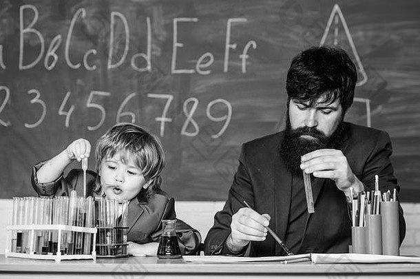 小学生在化学课上的自信魅力。回到学校。父亲和儿子在学校。科学化学概念。有胡子的男老师和小男孩。教育是一项与生俱来的权利。
