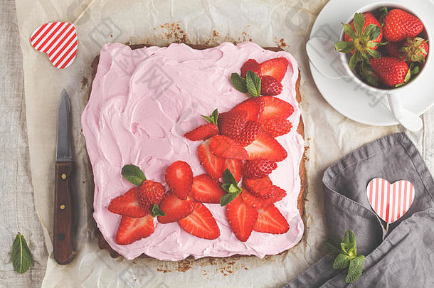 早餐用酸奶磅蛋糕配粉红色釉料和草莓。浅色背景，夏日甜点。俯视图，空间。