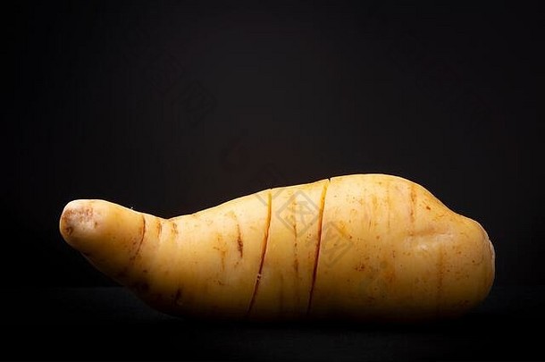 大黄色的甜蜜的土豆标志着削减工作室低关键食物生活对比黑暗背景