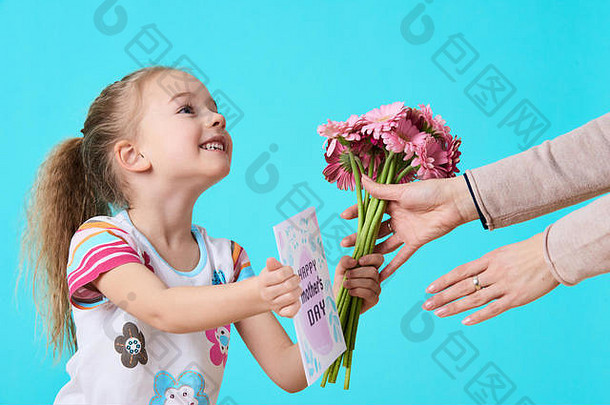 快乐母亲的一天可爱的女孩给妈妈问候卡花束妈妈。女儿概念糖果蓝色的柔和的背景