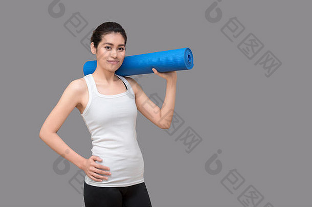 一位年轻的亚洲女子在健康运动<strong>馆</strong>拿着她的<strong>瑜伽</strong>垫。<strong>瑜伽</strong>和冥想对健康有益。