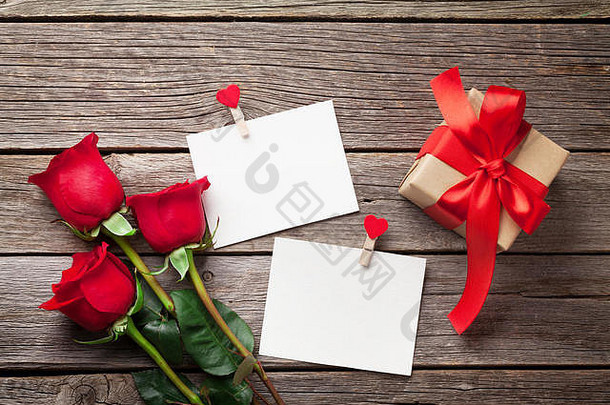 情人节一天问候卡红色的玫瑰花照片帧礼物盒子木表格前视图复制空间