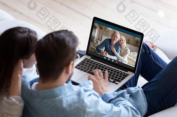 夫妇使用笔记本电脑和videocall应用程序与年迈的父母交流