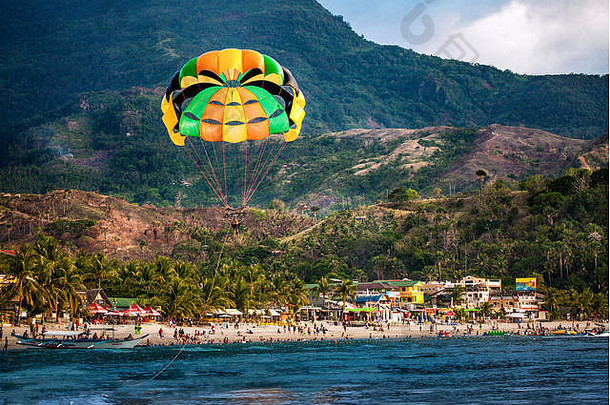 菲律宾明都罗东部的加莱拉港，数百人在白色海滩上乘伞度假。