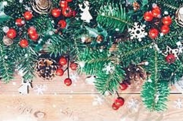 圣诞边框，木质背景上有冷杉树枝、红色冬青浆果、球果和雪花
