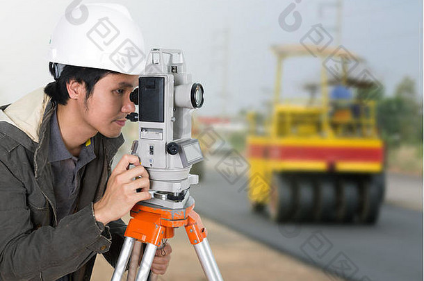 工程师在施工背景下使用测量设备经纬仪和道路