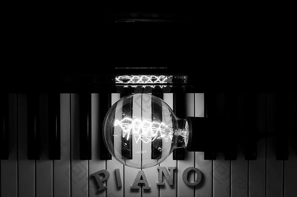 钢琴上用黑白灯点亮的灯泡