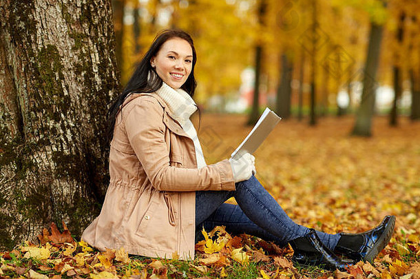 在秋天公园读书的女人