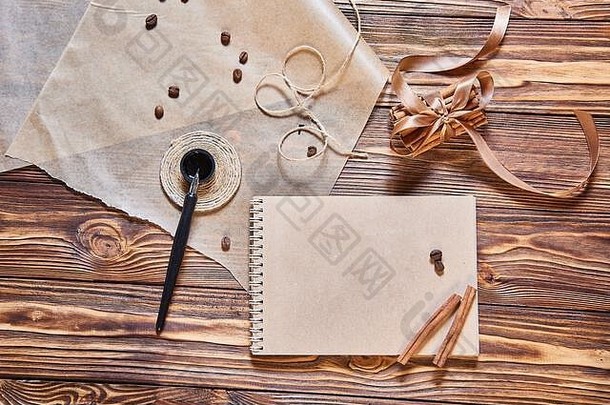 墨水笔、工艺笔记本和木桌上的肉桂