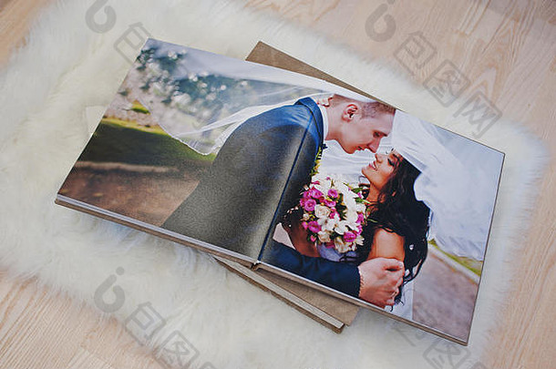木制背景地毯上的结婚照簿或结婚相册。