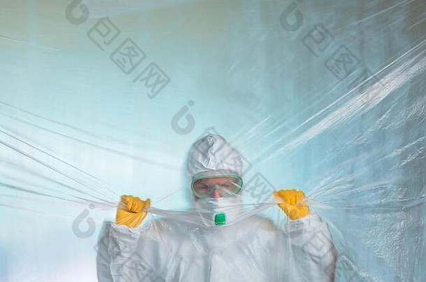 忧心忡忡精疲力竭的流行病学家被困在病毒检疫的塑料<strong>帘子</strong>后面，穿着防护服的医学专业人员，选择重点