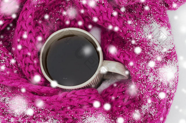 茶或咖啡的特写镜头和雪中的冬季围巾