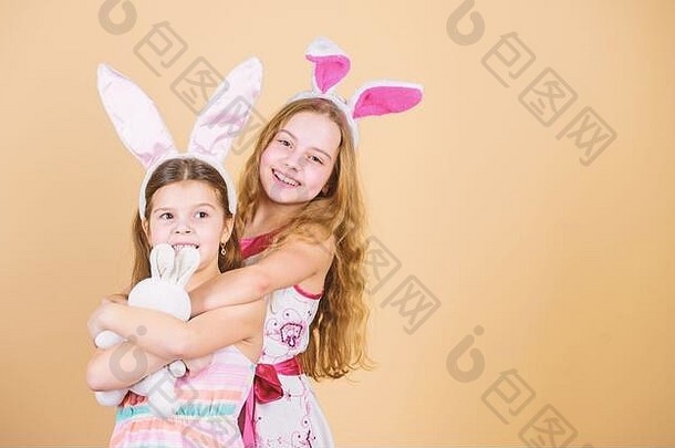 复活节快乐。有着长长的兔子耳朵的节日兔子女孩。儿童兔子服装。顽皮的女孩姐妹庆祝复活节。春假。快乐的童年。复活节。孩子们的复活节活动。