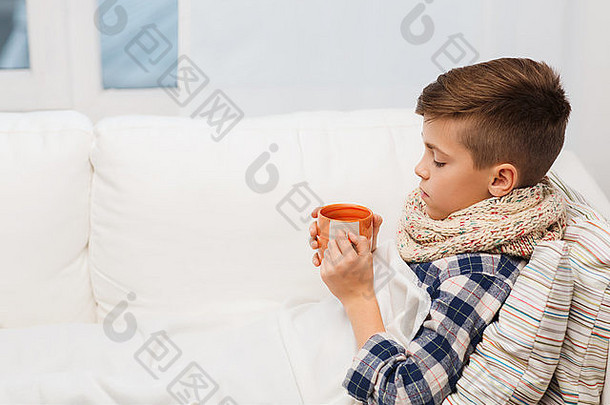 戴着围巾在家喝茶的流感病童