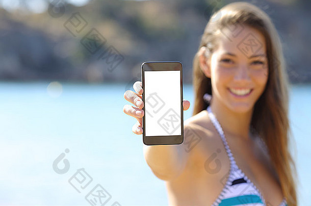 <strong>夏日</strong>假期，一位身穿比基尼的日光浴妇女在海滩上展示空白的手机屏幕