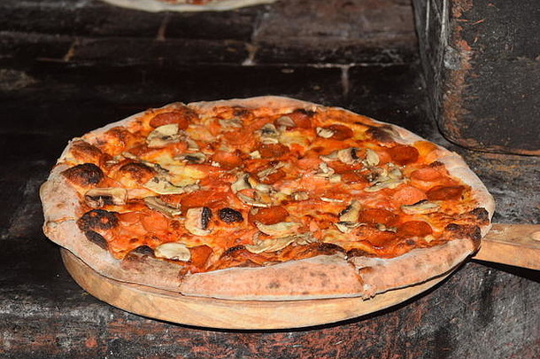 在菲律宾碧瑶市的一家餐厅里，新鲜的意大利<strong>原汁原味</strong>比萨饼在传统的意大利木火石砖烤箱中制作和烘焙