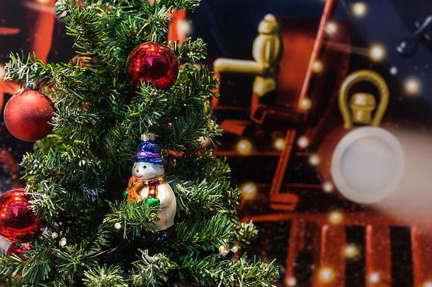 一棵圣诞树，上面装饰着花环、红球和雪人。这是一个传统的12月25日，节日和家庭。