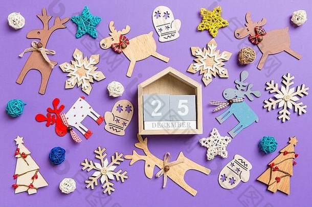 紫色<strong>背景</strong>上的节日装饰品和玩具。木制日历的俯视图。十<strong>二月二</strong>十五日。圣诞快乐。