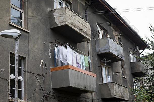 保加利亚索非亚贫民区阳台上晾晒衣物的破旧公寓楼