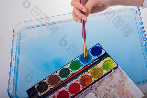 画笔接触水时，油漆溶解在水中