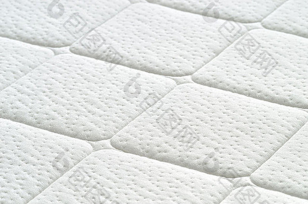 白色床垫纹理的特写镜头。绗缝材料的图案。舒适的床垫。空间。