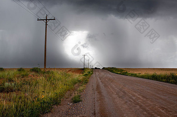 乡村雷雨场景——泥泞的道路通向天空中的亮光，阴暗的积<strong>云</strong>密布着雷雨