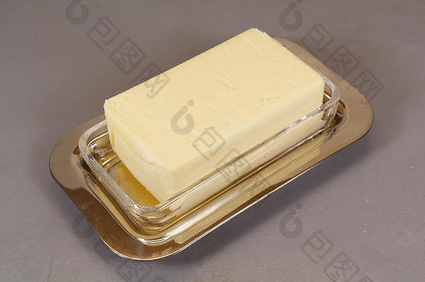 用金属和玻璃制成的黄油盘中的黄油包