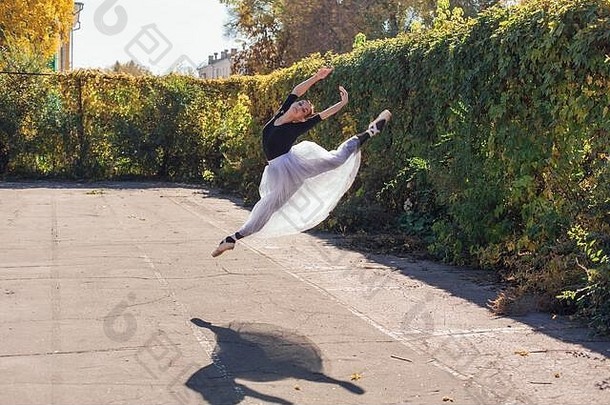 女人芭蕾舞女演员白色芭蕾舞裙子跳舞尖端鞋子秋天公园