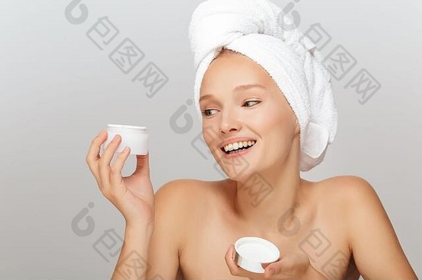 肖像快乐的女孩化妆白色毛巾头持有脸奶油手幸福的灰色的背景