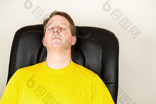 水平照片，成年男子闭着眼睛在按摩椅上放松